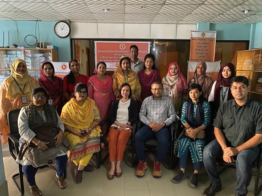 UNFPA - November training in Bangladesh. People are seated/standing around one another. Dr. Susan Cu-Uvin and Dr. Ruhul Abid are in the foreground.