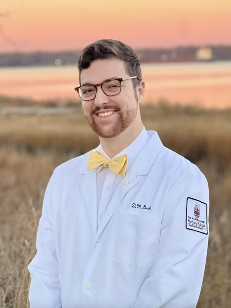 Dylan Bush in a white lab coat with a yellow bow tie