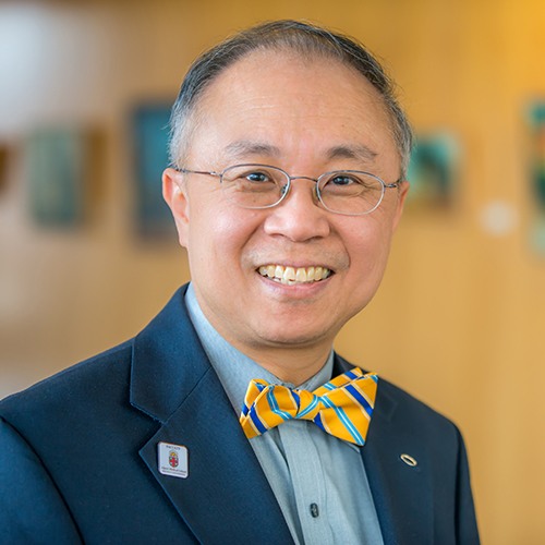Portrait of James Sung with a yellow bowtie and a blue suit