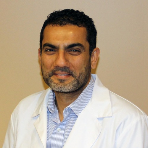 Photo of Siraj Amanullah in a white lab coat