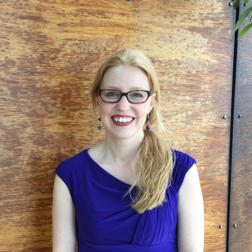 Photo of Dr. Nicole Nugent in a blue shirt against a wooden background
