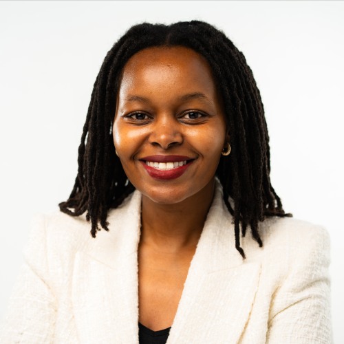 Joan Chepngeno in a white suit standing against a white background