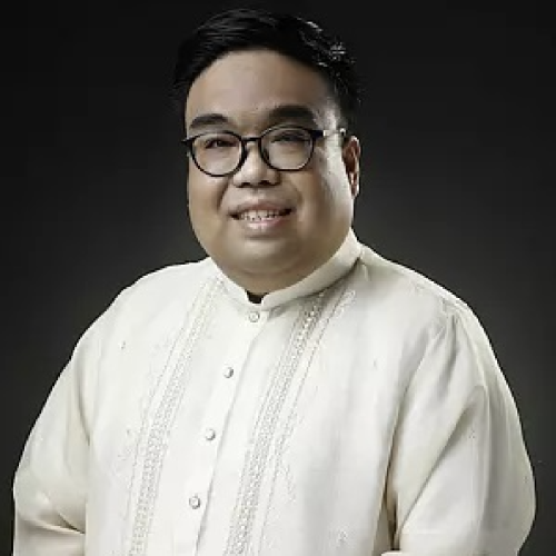 Portrait of Amiel Bermudez in a white shirt with black rimmed glasses 